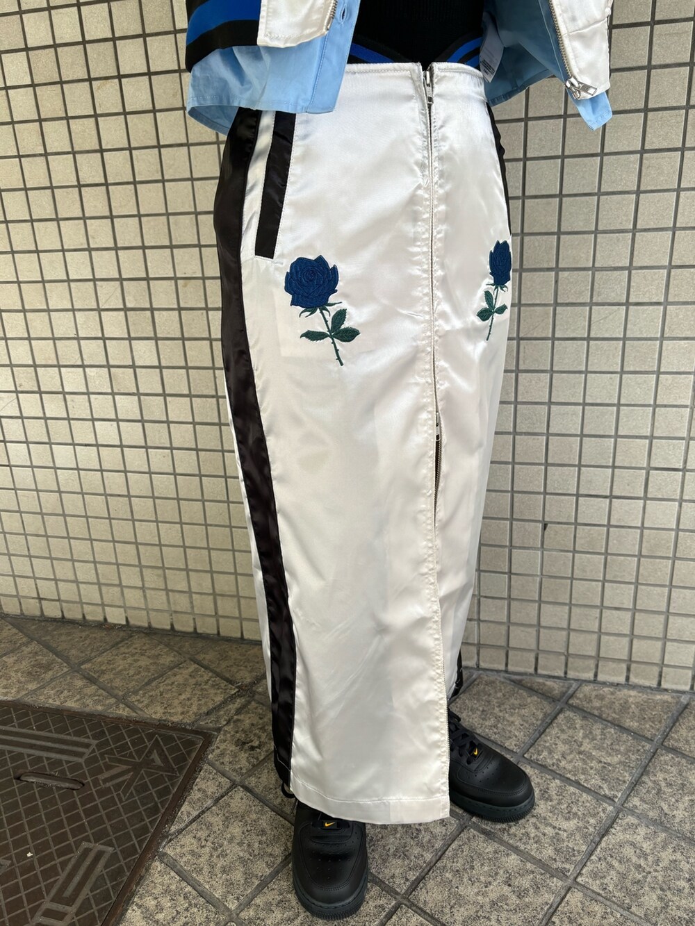 ホワイト系のスカート、ブルー系のシャツ/ブラウス、ブラック系のニット/セーターを着用したレディースの春コーディネートの10枚目の写真