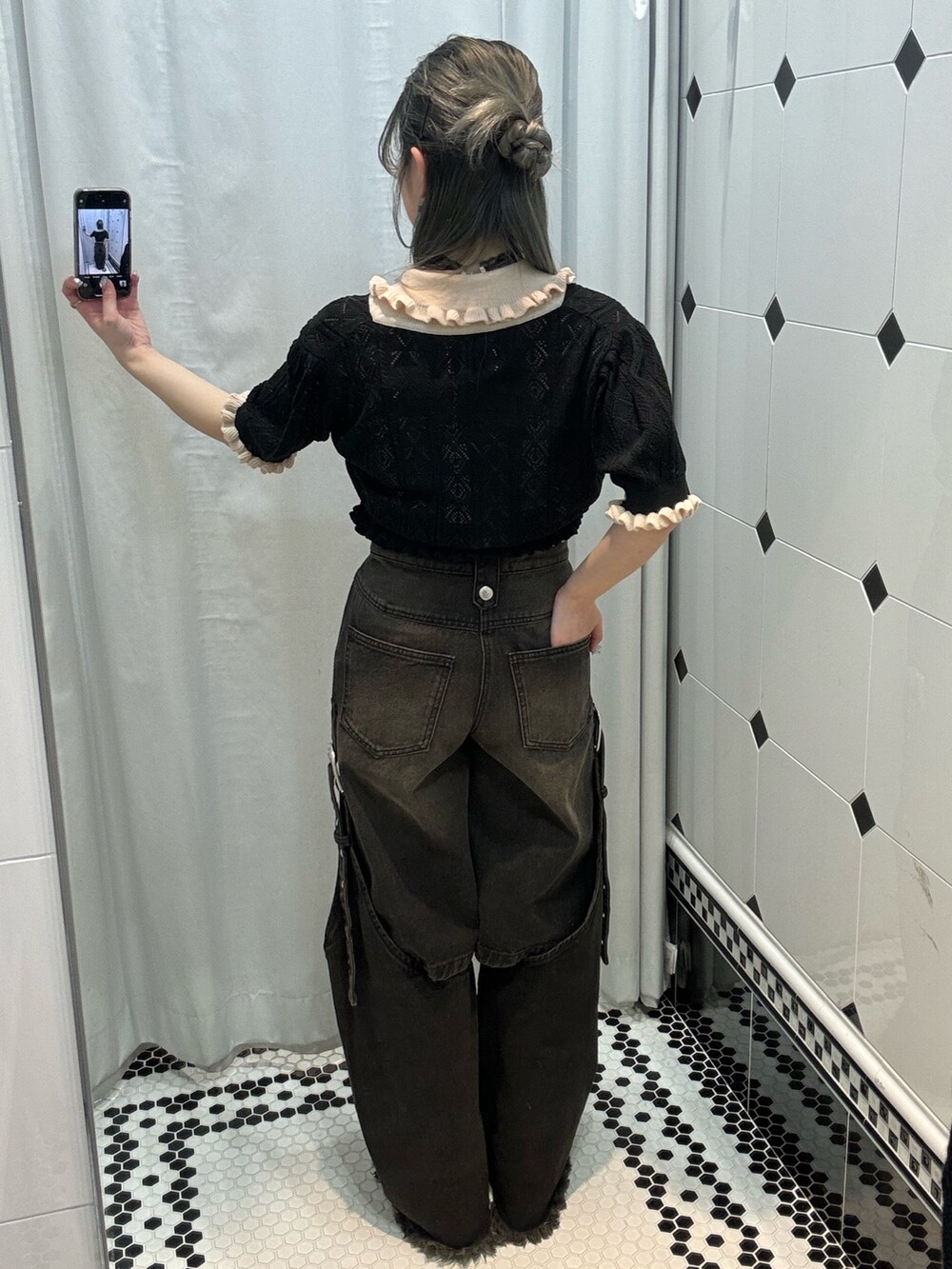 ブラック系のデニムパンツ、ブラック系のブーツ、ホワイト系のキャミソールを着用したレディースの春コーディネートの3枚目の写真