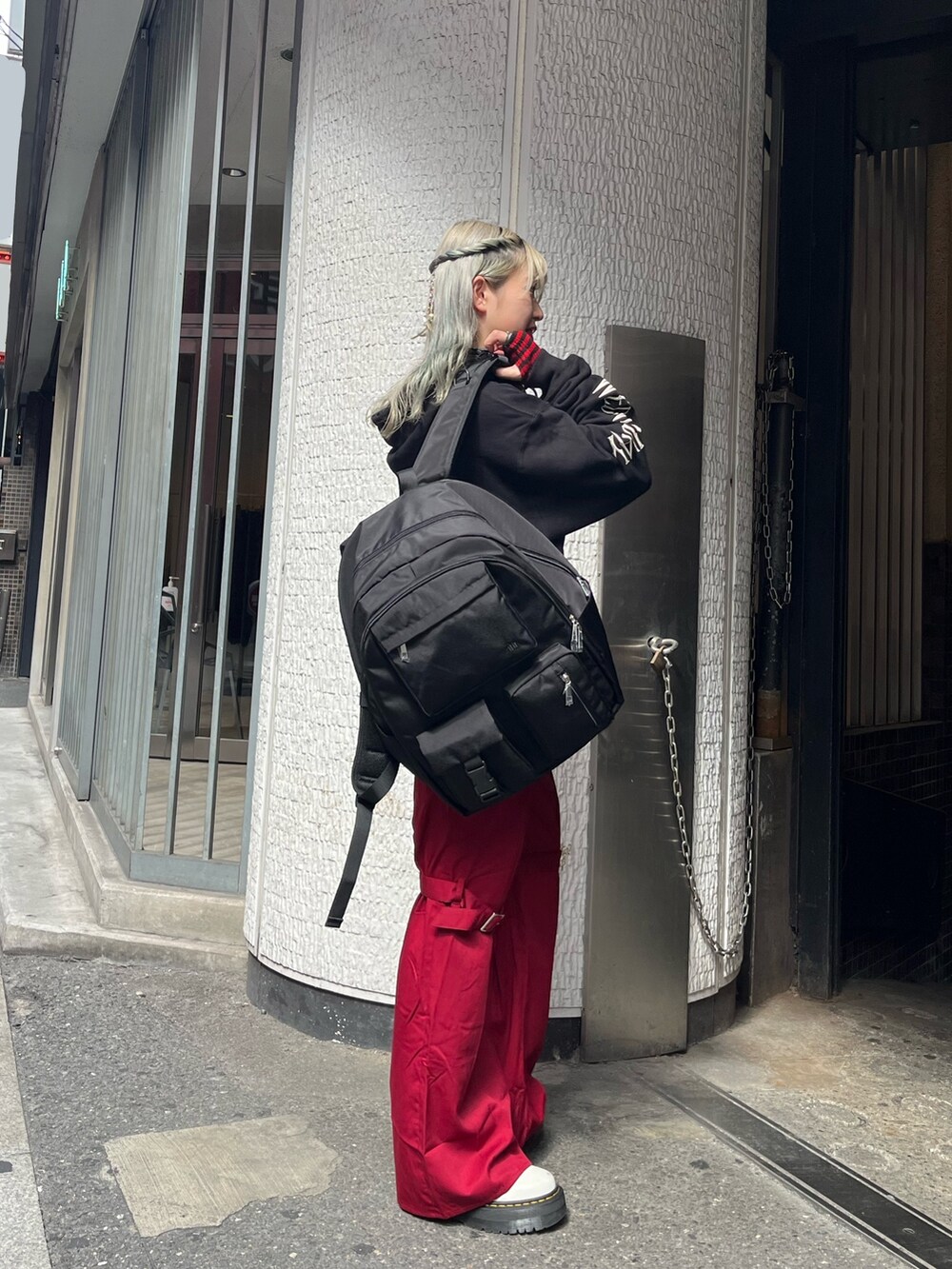 ブラック系のバックパック/リュック、ブラック系のパーカー、レッド系のその他パンツを着用したレディースの秋コーディネートの2枚目の写真