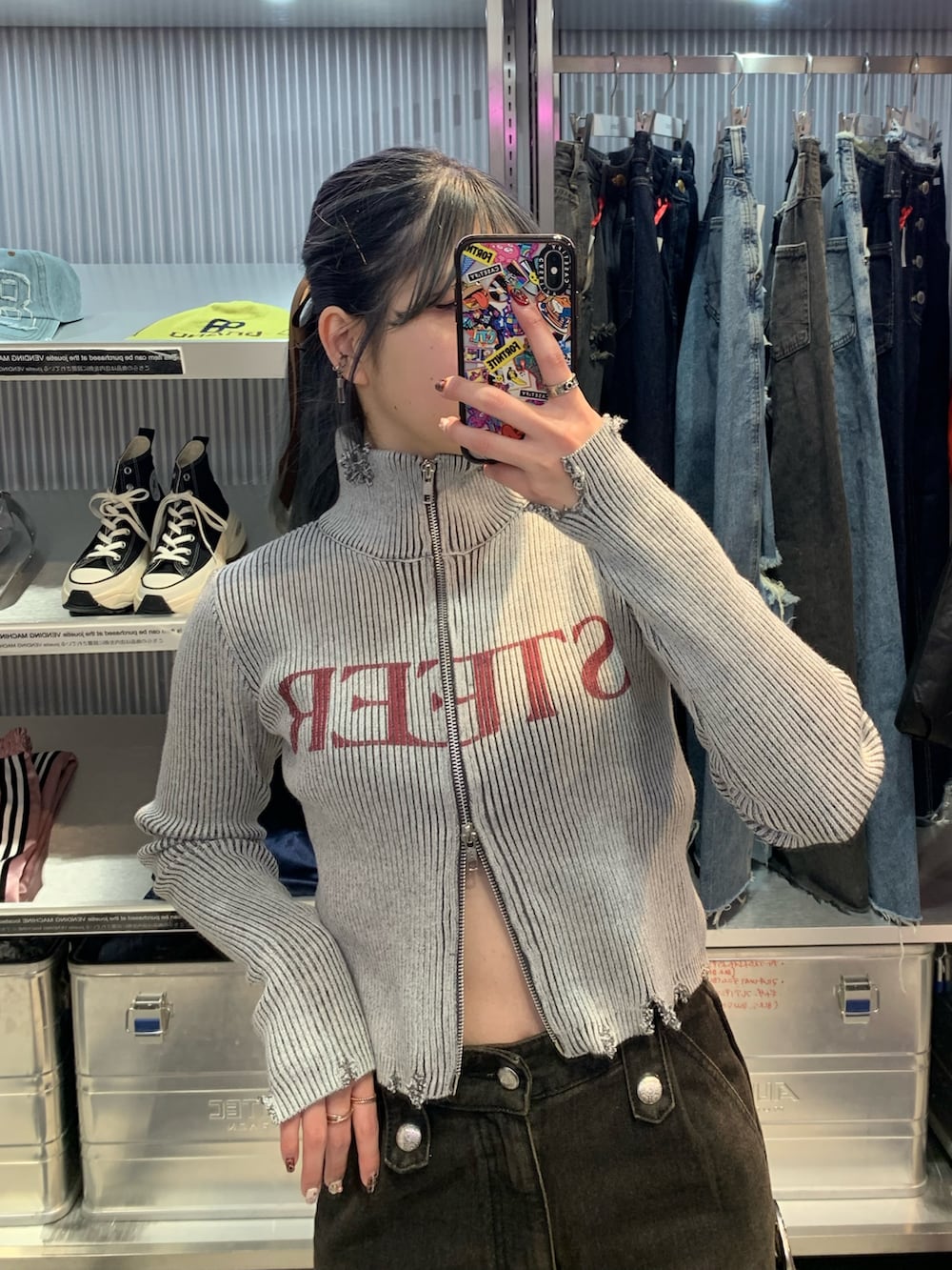 ブラック系のデニムパンツ、ブラック系のその他シューズ、グレー系のニット/セーターを着用したレディースの春コーディネートの4枚目の写真