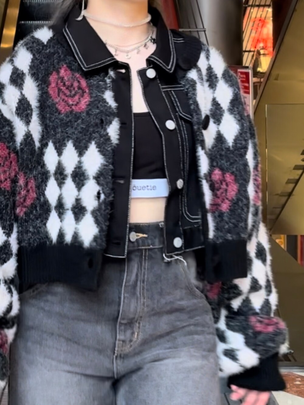 ブラック系のデニムパンツ、ブラック系のワンピース、ブラック系のカーディガン/ボレロを着用したレディースの秋コーディネートの4枚目の写真