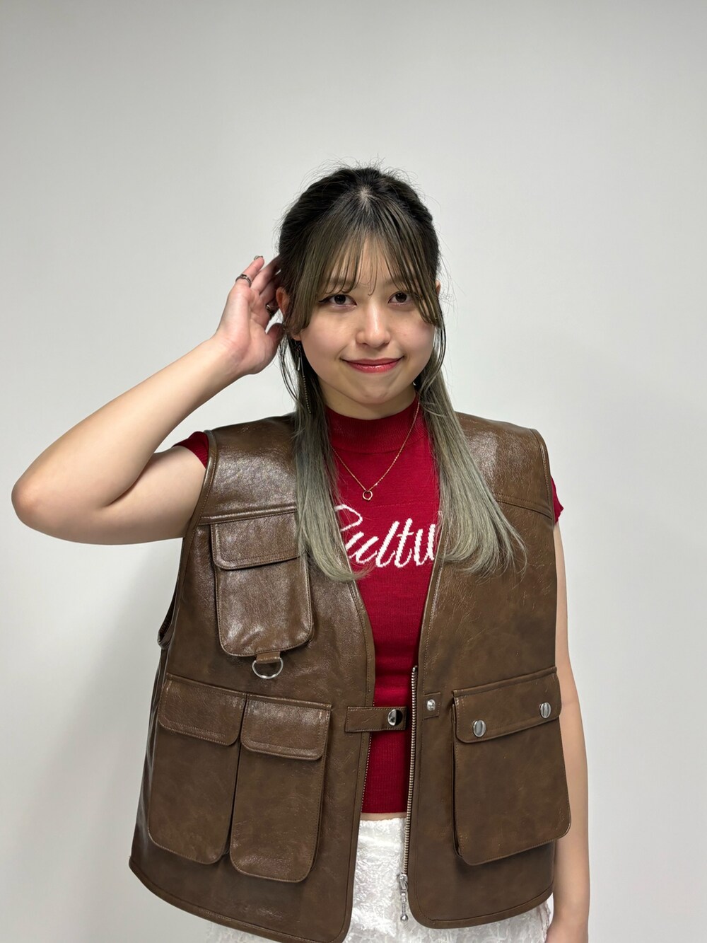 ホワイト系のその他パンツ、レッド系のニット/セーター、ブラウン系のベストを着用したレディースの春コーディネートの5枚目の写真