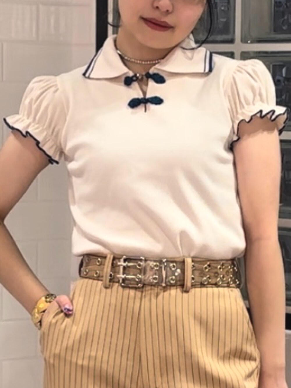 ベージュ系のその他パンツ、ブラック系のその他シューズ、ホワイト系のポロシャツを着用したレディースの冬コーディネートの5枚目の写真