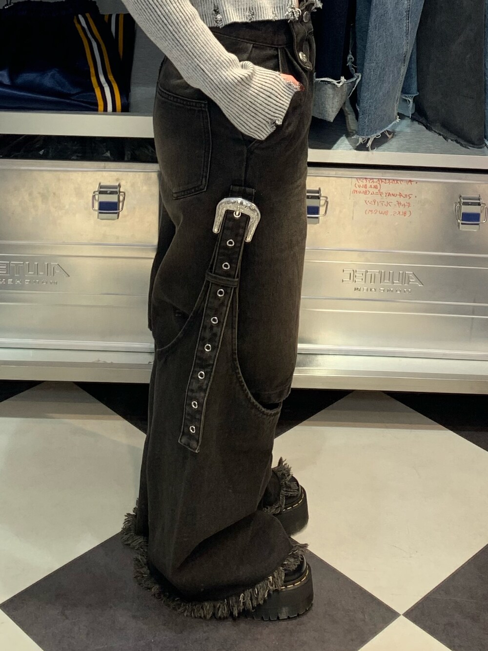 ブラック系のデニムパンツ、ブラック系のその他シューズ、グレー系のニット/セーターを着用したレディースの春コーディネートの6枚目の写真