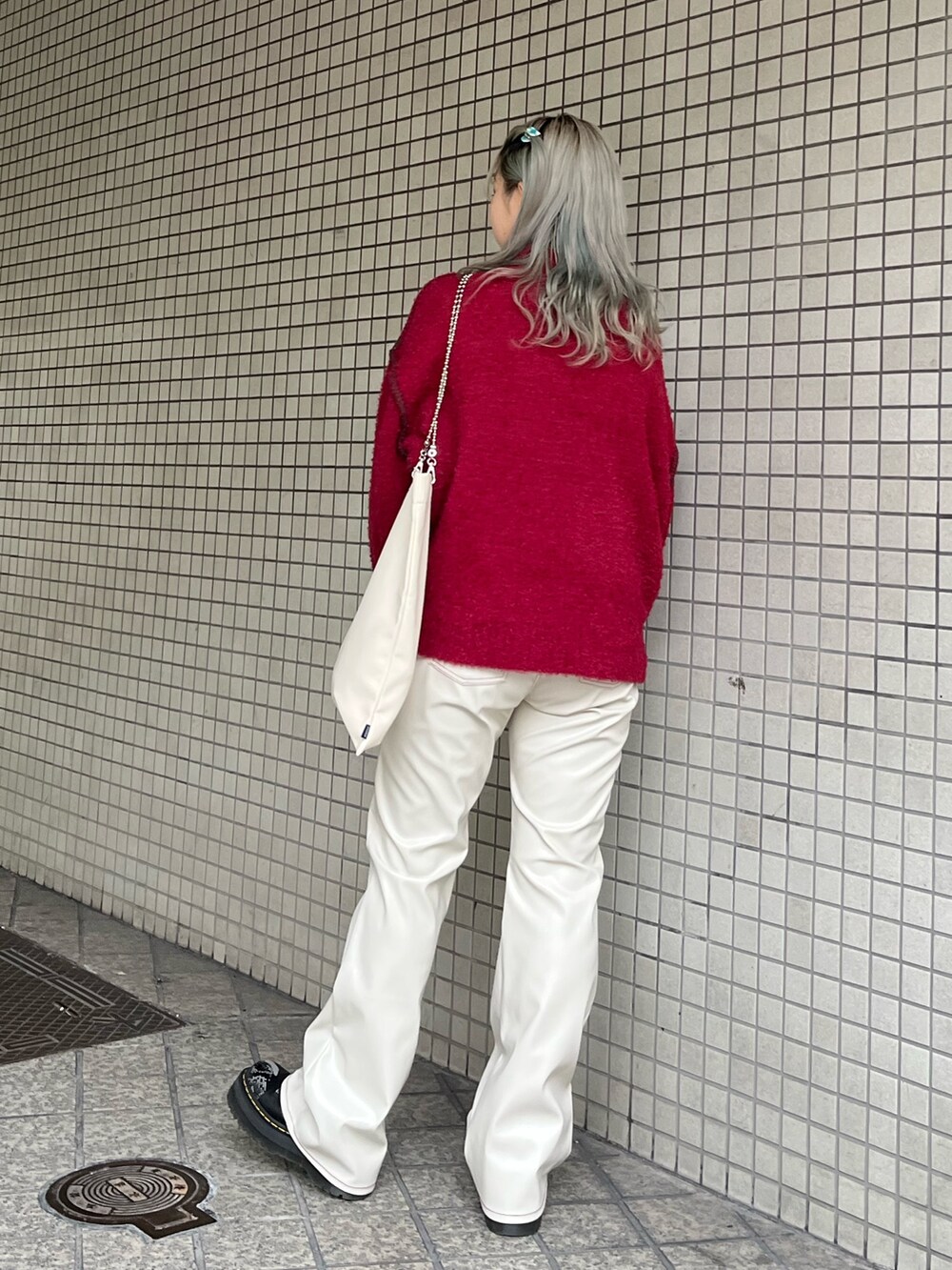 ホワイト系のハンドバッグ、レッド系のニット/セーター、ホワイト系のその他パンツを着用したレディースの冬コーディネートの3枚目の写真