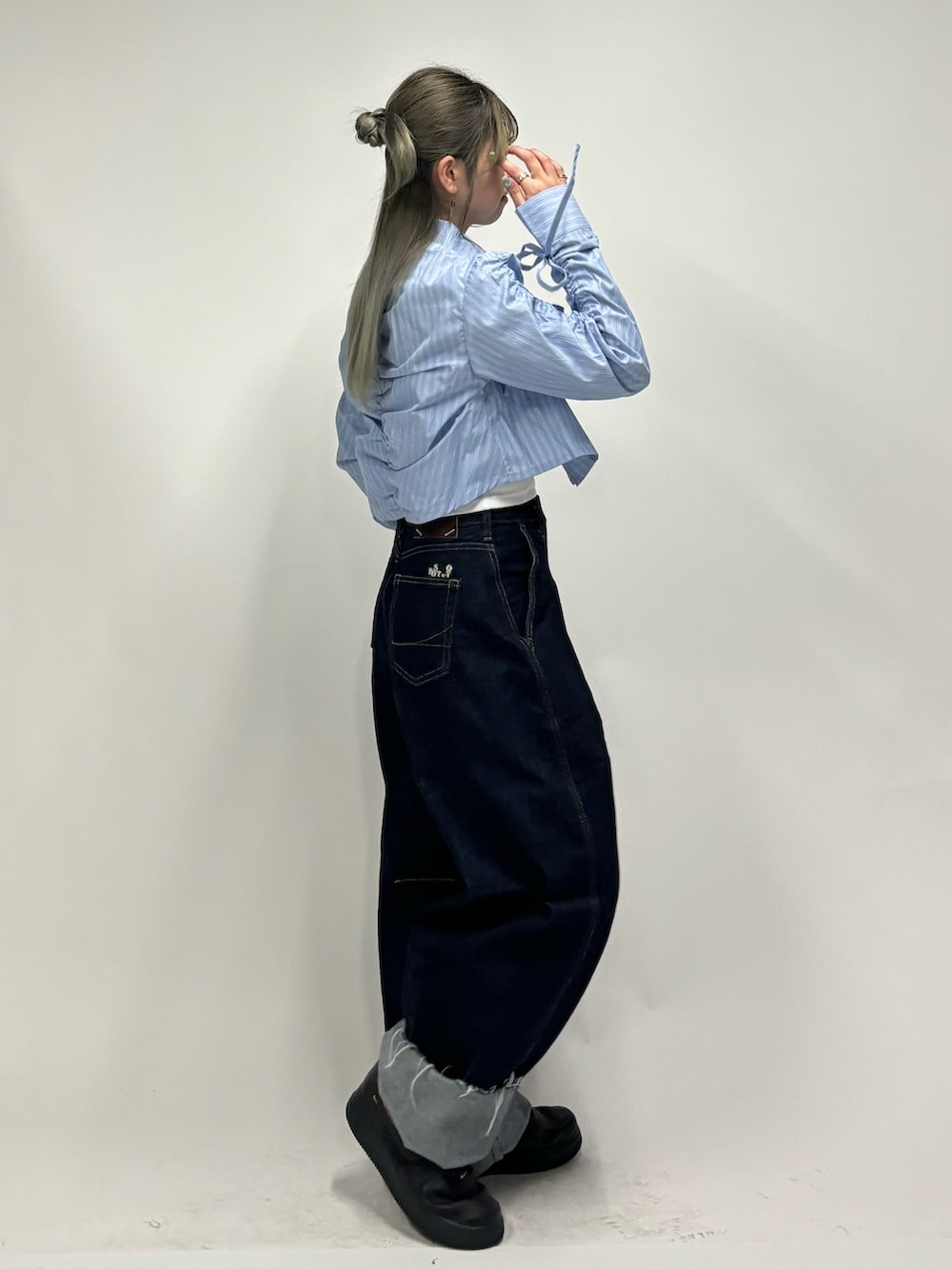 ブルー系のデニムパンツ、ホワイト系のキャミソール、ブルー系のシャツ/ブラウスを着用したレディースの春コーディネートの2枚目の写真