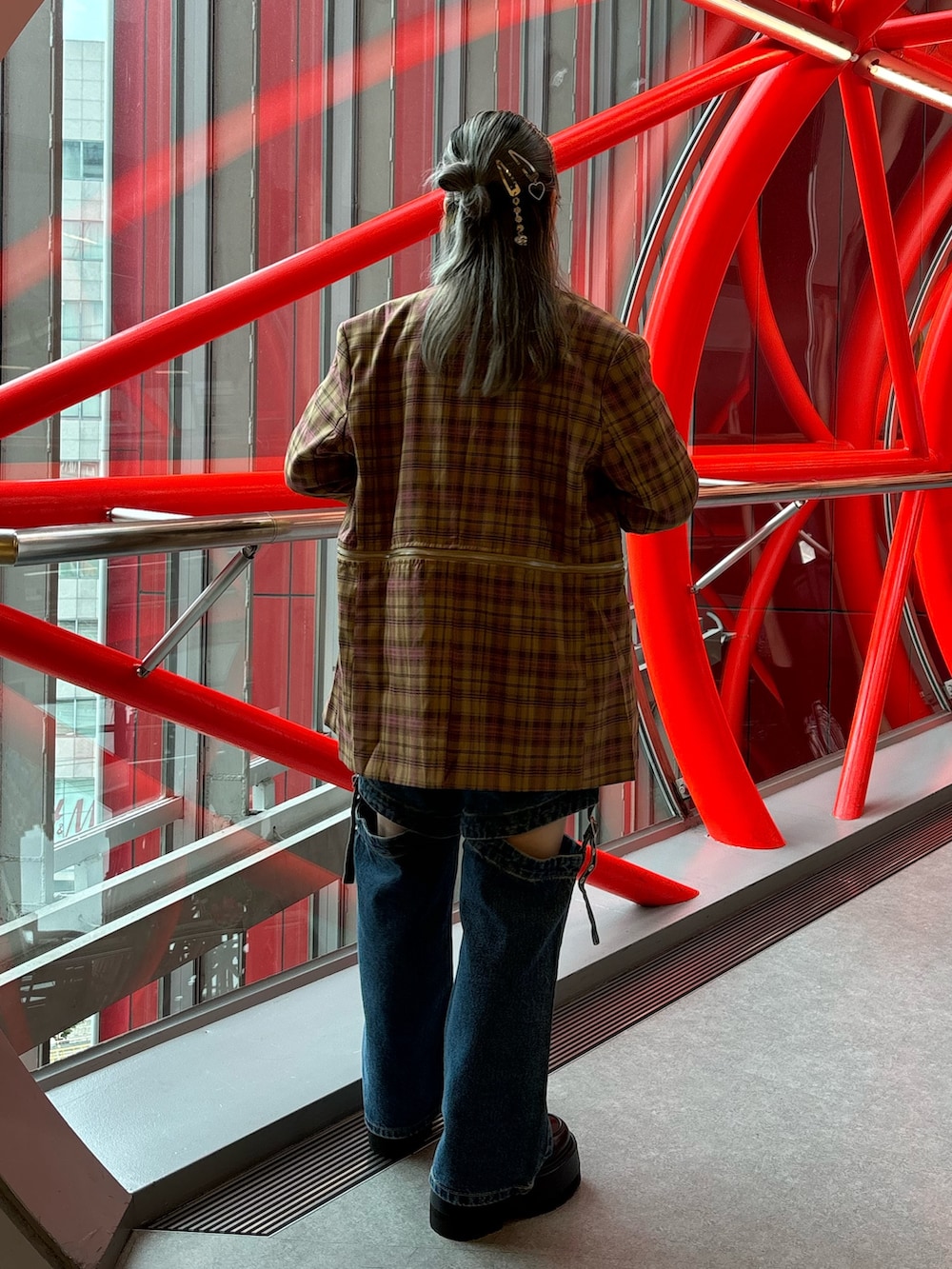 ブルー系のデニムパンツ、ブラック系のドレスシューズ、ブラウン系のテーラードジャケットを着用したレディースの夏コーディネートの3枚目の写真