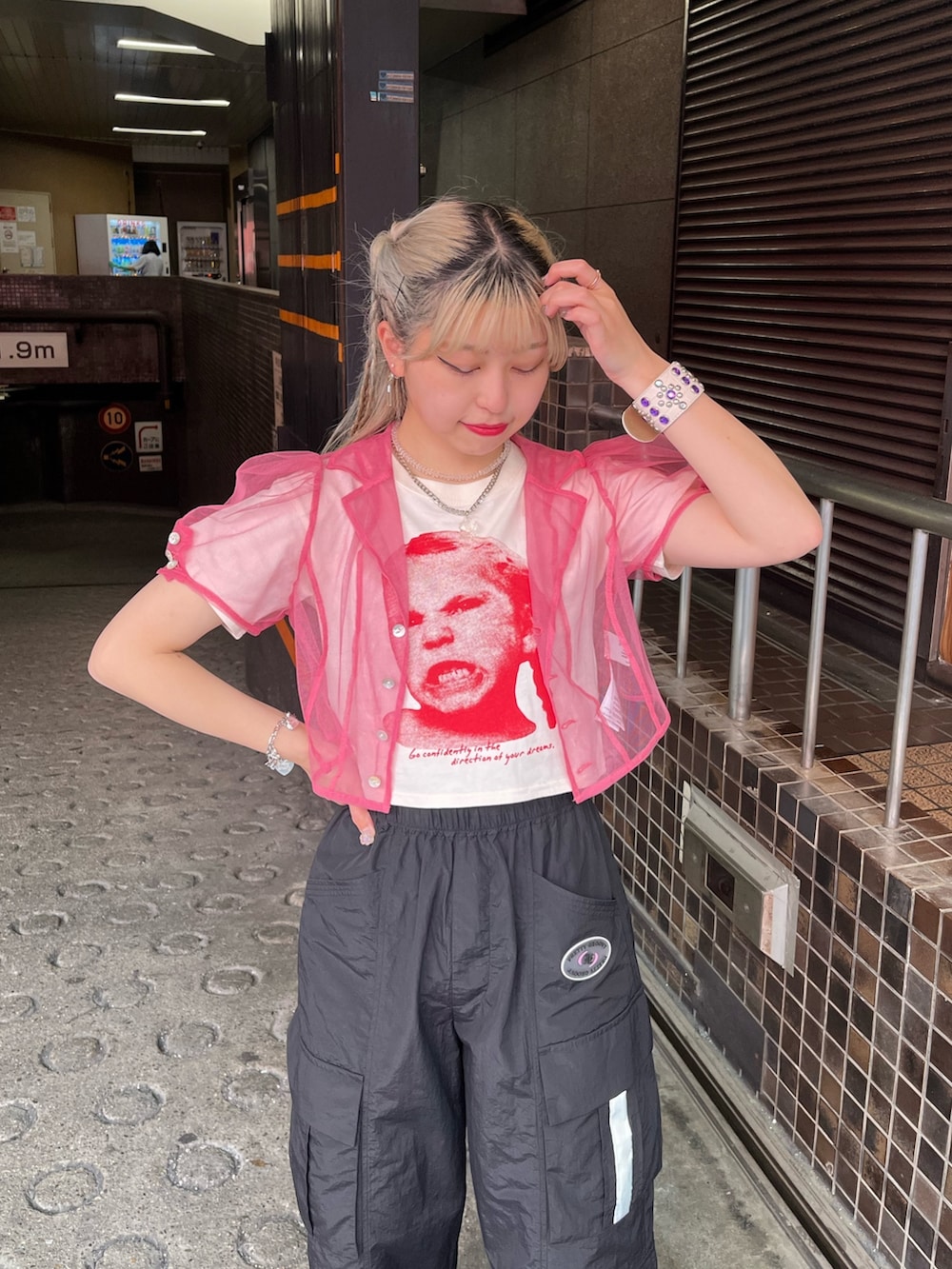 ブラック系のサンダル、ブラック系のカーゴパンツ、ホワイト系のTシャツ/カットソーを着用したレディースの夏コーディネートの3枚目の写真