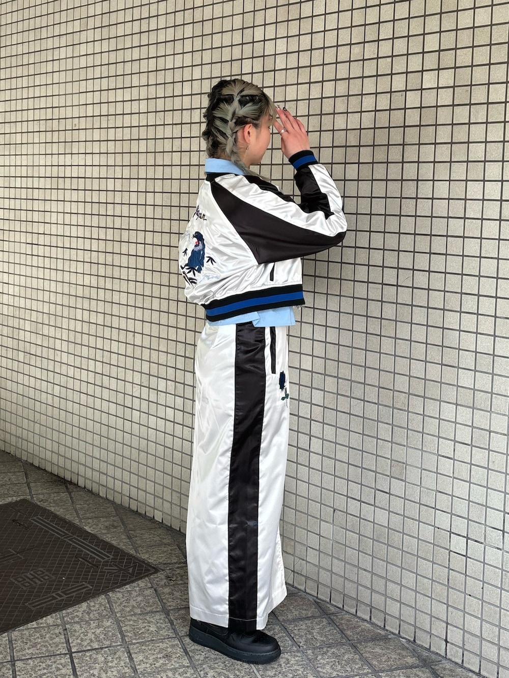 ホワイト系のスカート、ブルー系のシャツ/ブラウス、ブラック系のニット/セーターを着用したレディースの春コーディネートの2枚目の写真