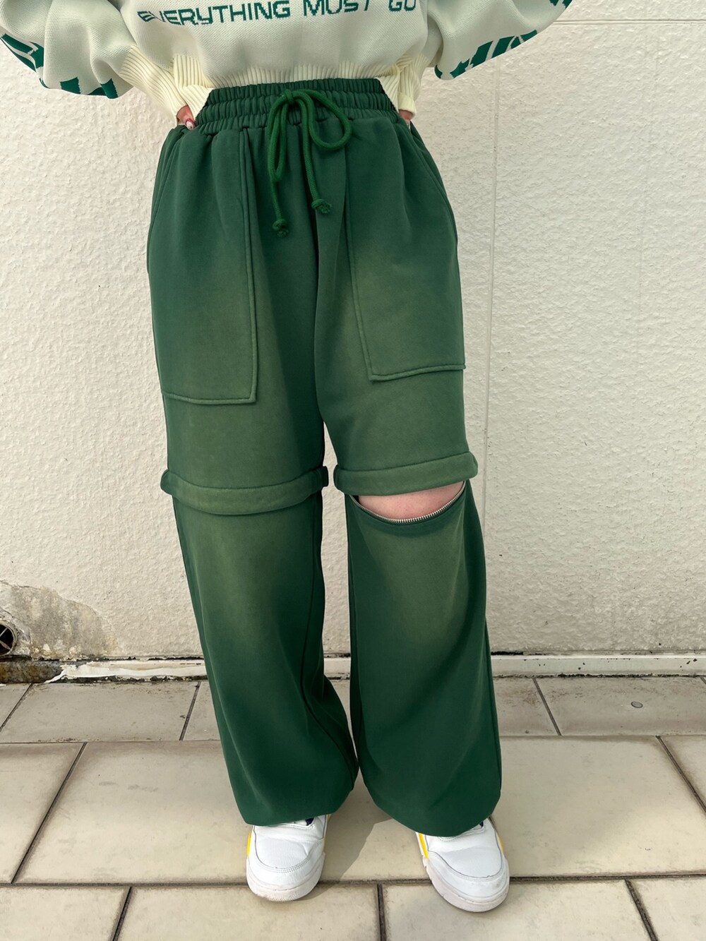 グリーン系のスウェットパンツ、ホワイト系のニット/セーター、シルバー系のネックレスを着用したレディースの冬コーディネートの9枚目の写真