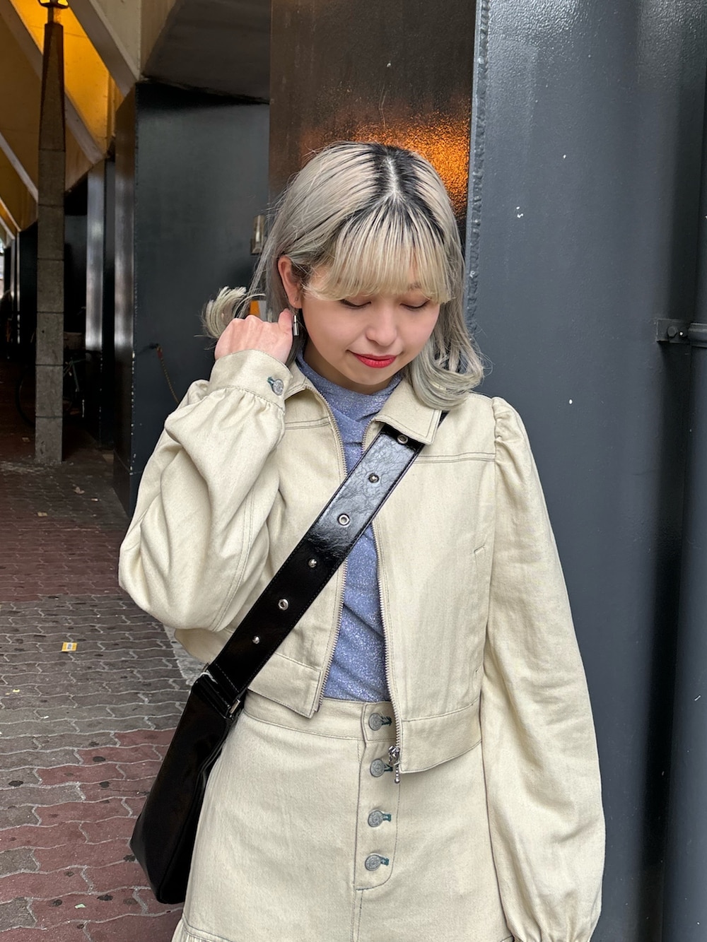 ブラック系のショルダーバッグ、ブルー系のTシャツ/カットソー、ホワイト系のワンピースを着用したレディースの春コーディネートの5枚目の写真