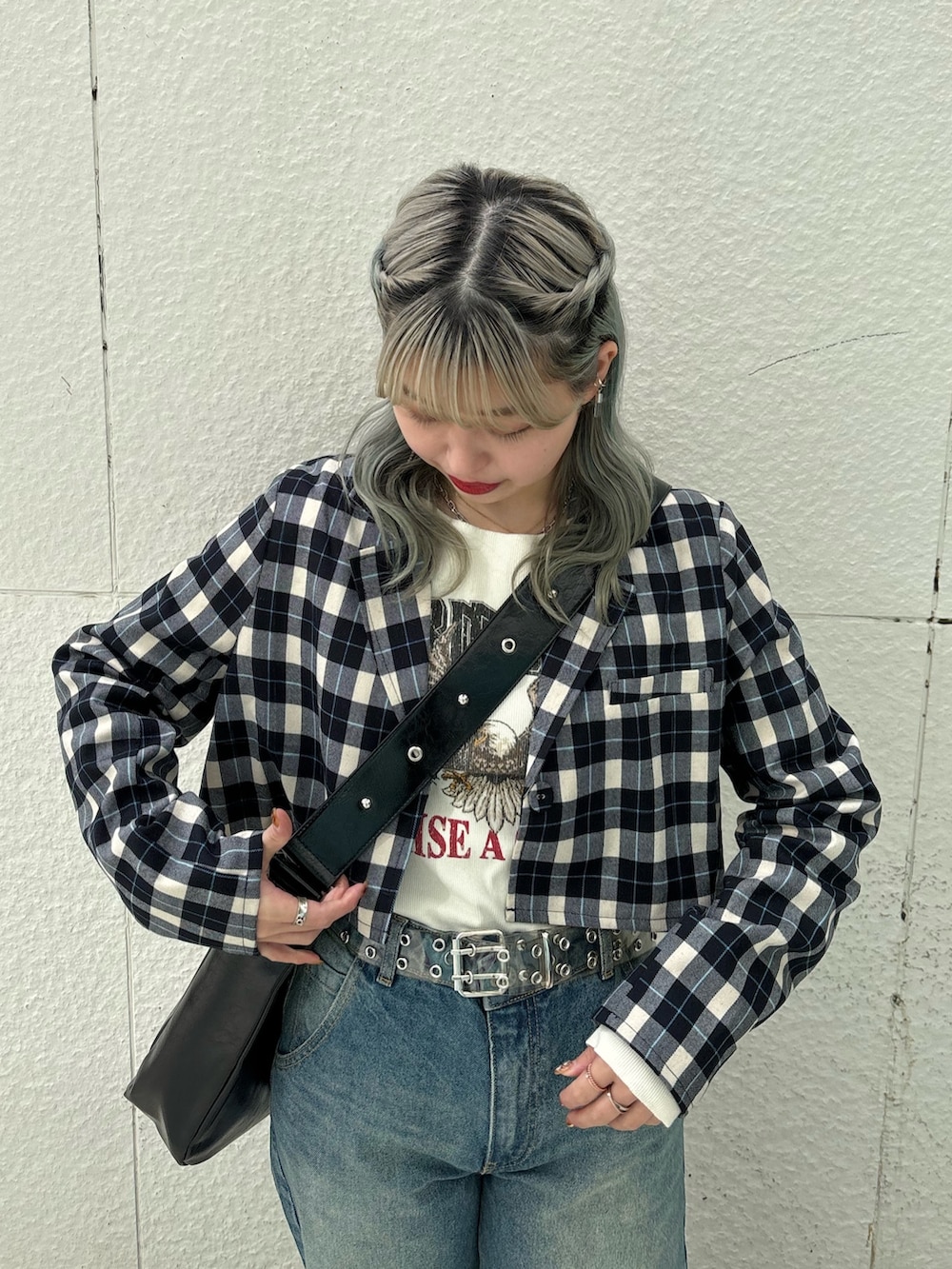 ブルー系のデニムパンツ、ブラック系のショルダーバッグ、ホワイト系のTシャツ/カットソーを着用したレディースの冬コーディネートの6枚目の写真