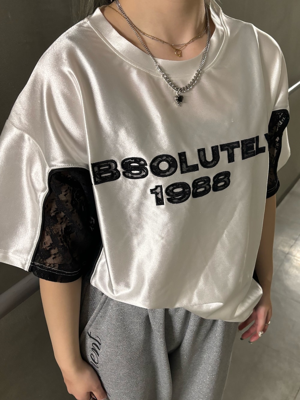 グレー系のスウェットパンツ、ホワイト系のTシャツ/カットソー、シルバー系のネックレスを着用したレディースの春コーディネートの6枚目の写真