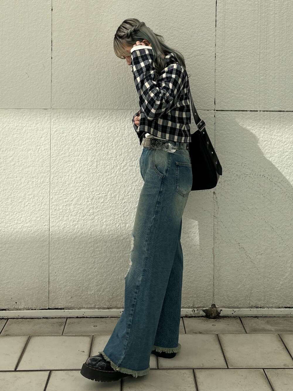 ブルー系のデニムパンツ、ブラック系のショルダーバッグ、ホワイト系のTシャツ/カットソーを着用したレディースの冬コーディネートの4枚目の写真