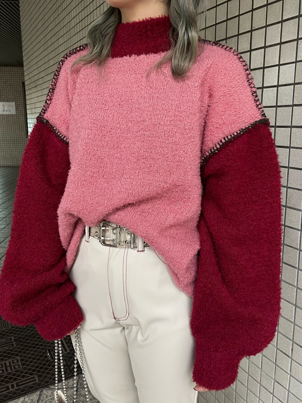 ホワイト系のハンドバッグ、レッド系のニット/セーター、ホワイト系のその他パンツを着用したレディースの冬コーディネートの5枚目の写真