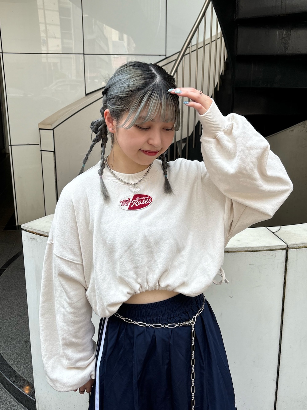 ブルー系のスカート、ホワイト系のスウェット、シルバー系のベルトを着用したレディースの夏コーディネートの4枚目の写真