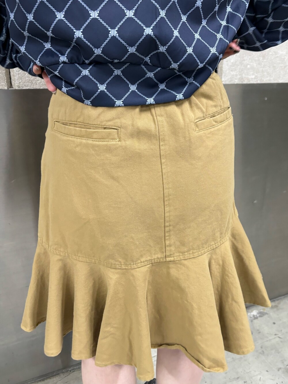 ベージュ系のスカート、ピンク系のニット/セーター、ブルー系のジャージを着用したレディースの春コーディネートの9枚目の写真