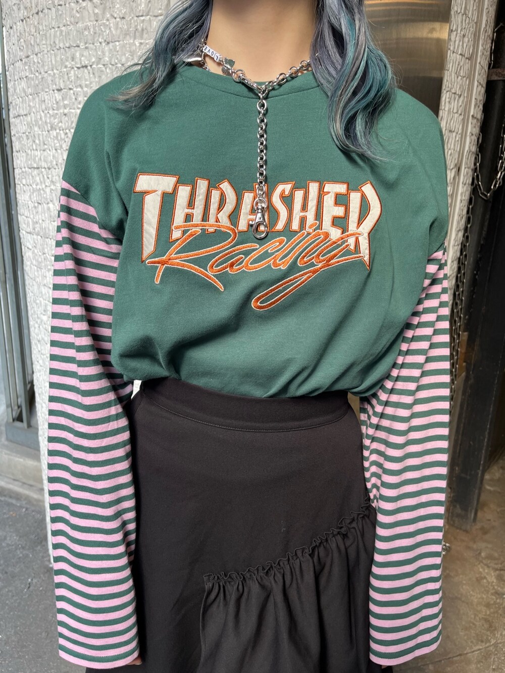 グリーン系のTシャツ/カットソー、ブラック系のスカート、シルバー系のネックレスを着用したレディースの秋コーディネートの7枚目の写真