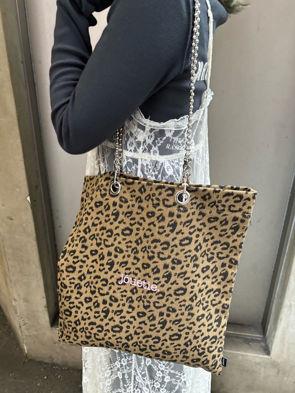 ホワイト系のワンピース、ブラック系のデニムパンツ、その他のトートバッグを着用したレディースの春コーディネートの10枚目の写真