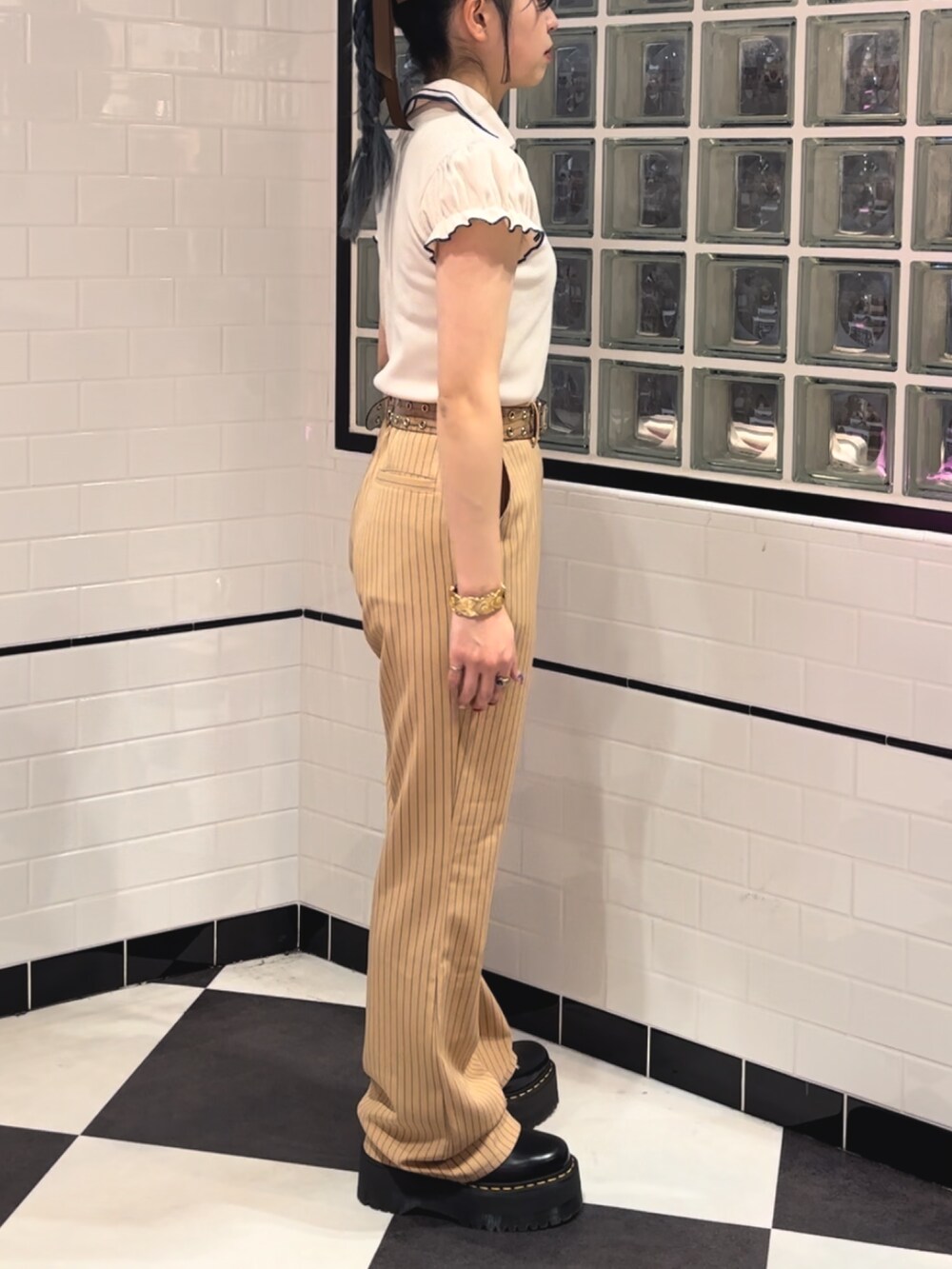 ベージュ系のその他パンツ、ブラック系のその他シューズ、ホワイト系のポロシャツを着用したレディースの冬コーディネートの2枚目の写真