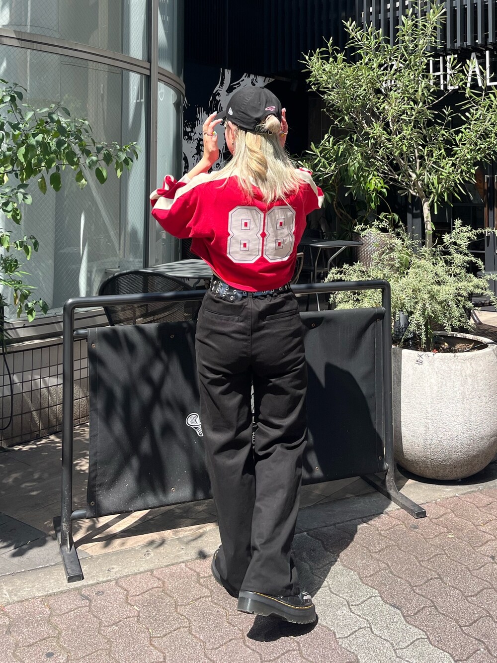 ブラック系のその他パンツ、レッド系のTシャツ/カットソー、シルバー系のネックレスを着用したレディースの秋コーディネートの4枚目の写真