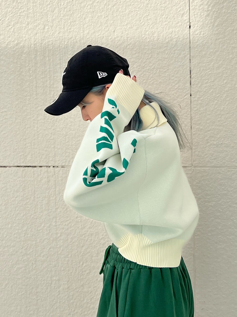 グリーン系のスウェットパンツ、ホワイト系のニット/セーター、シルバー系のネックレスを着用したレディースの冬コーディネートの6枚目の写真