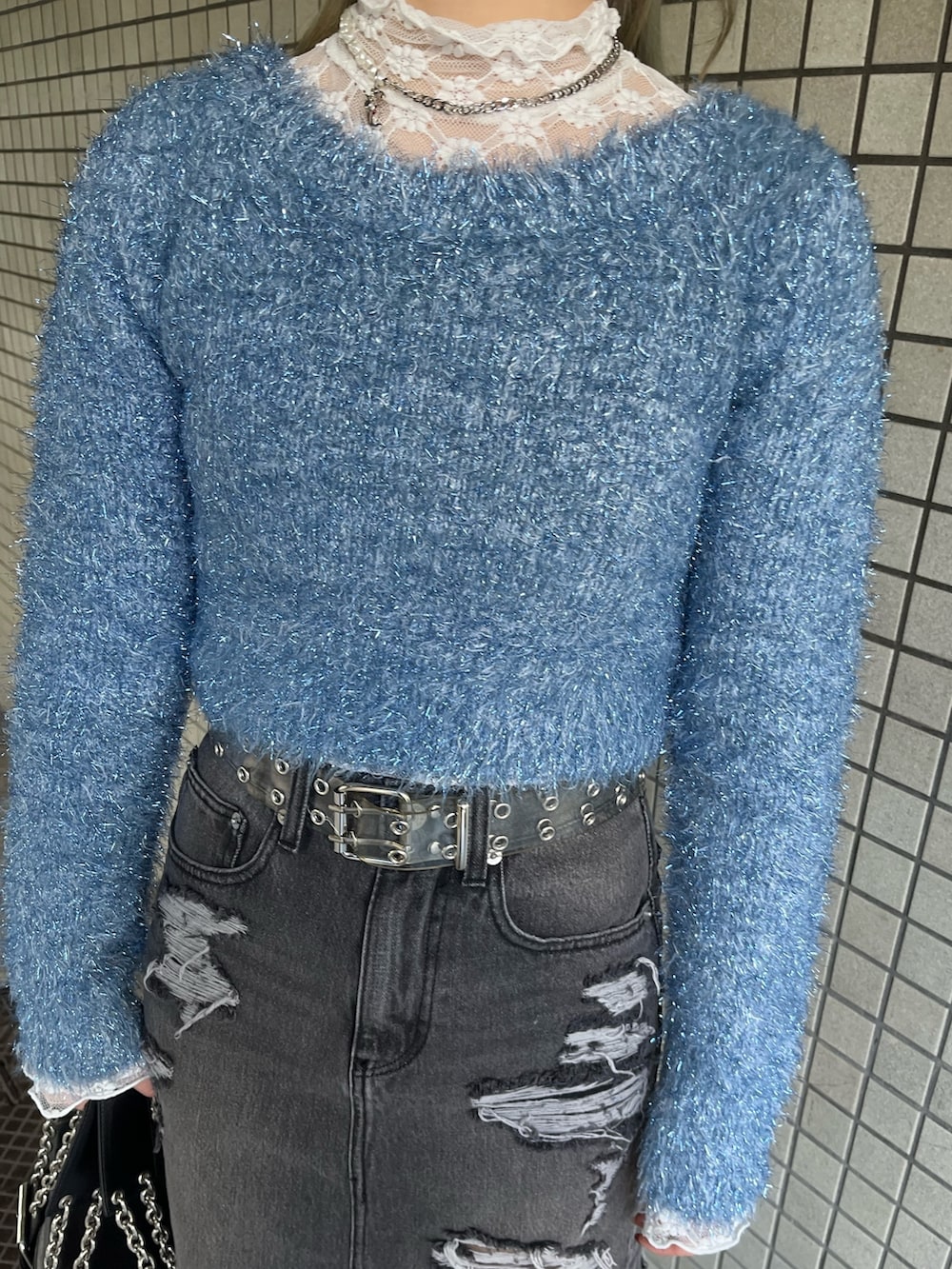 ホワイト系のTシャツ/カットソー、ブラック系のハンドバッグ、ブルー系のニット/セーターを着用したレディースの冬コーディネートの7枚目の写真