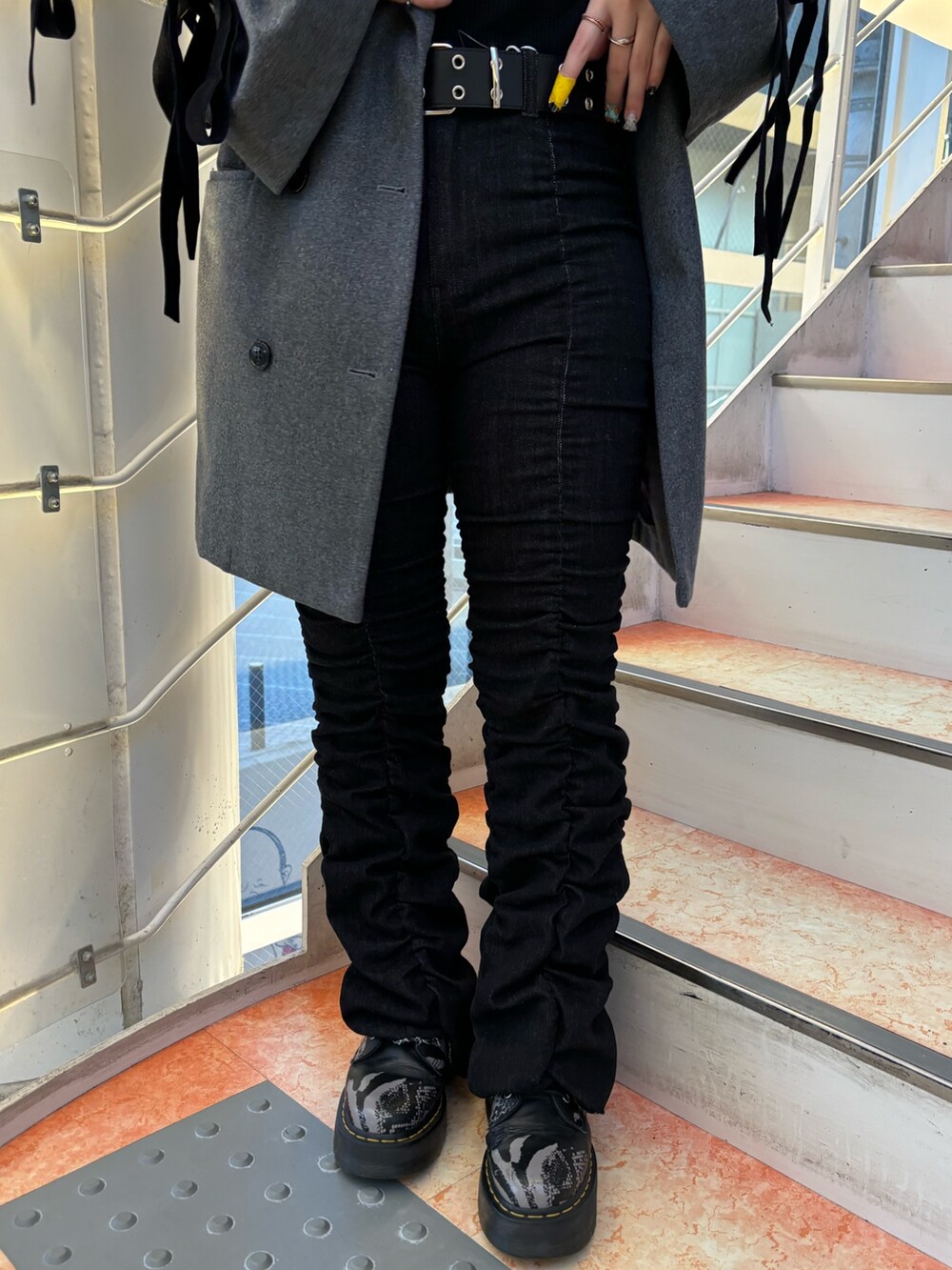 ブラック系のデニムパンツ、グレー系のその他アウター、ブラック系のTシャツ/カットソーを着用したレディースの秋コーディネートの7枚目の写真