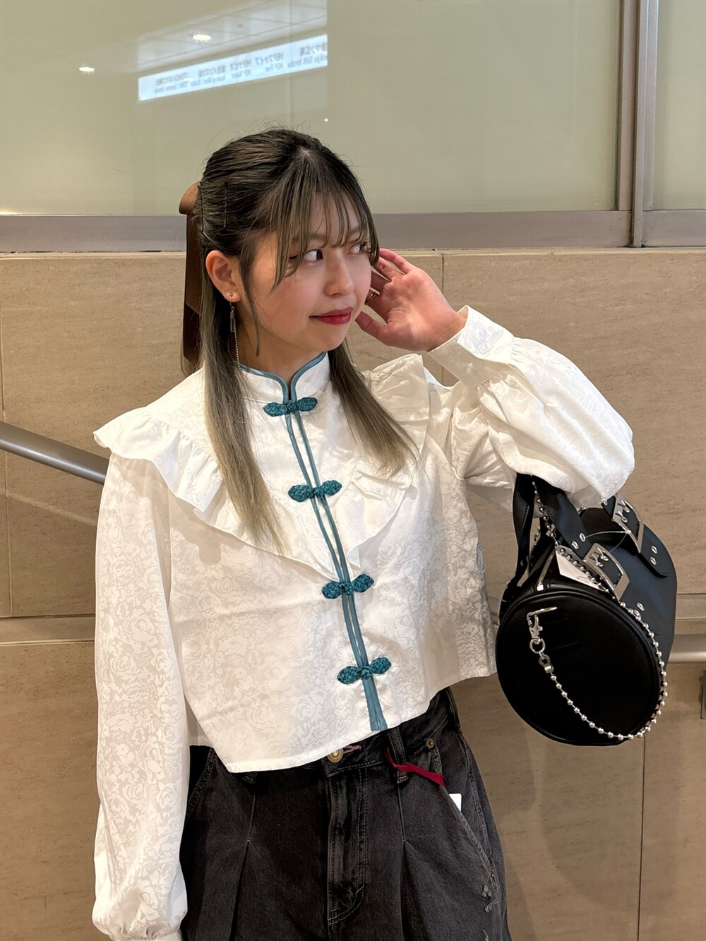 ブラック系のデニムパンツ、ブラック系のボストンバッグ、ホワイト系のシャツ/ブラウスを着用したレディースの春コーディネートの5枚目の写真