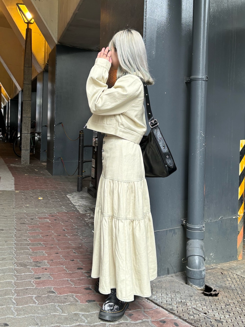 ブラック系のショルダーバッグ、ブルー系のTシャツ/カットソー、ホワイト系のワンピースを着用したレディースの春コーディネートの4枚目の写真