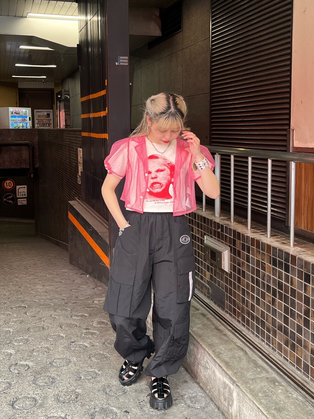 ブラック系のサンダル、ブラック系のカーゴパンツ、ホワイト系のTシャツ/カットソーを着用したレディースの夏コーディネートの2枚目の写真