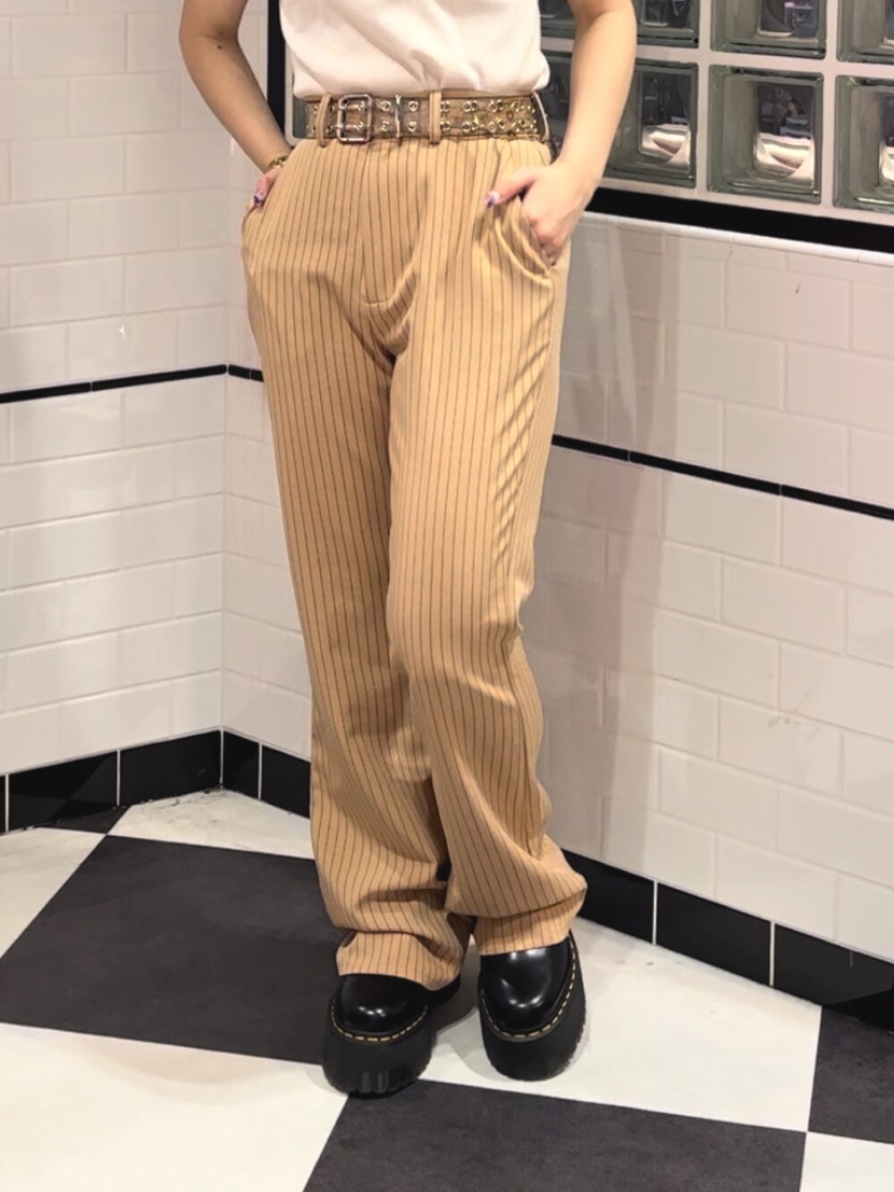 ベージュ系のその他パンツ、ブラック系のその他シューズ、ホワイト系のポロシャツを着用したレディースの冬コーディネートの6枚目の写真