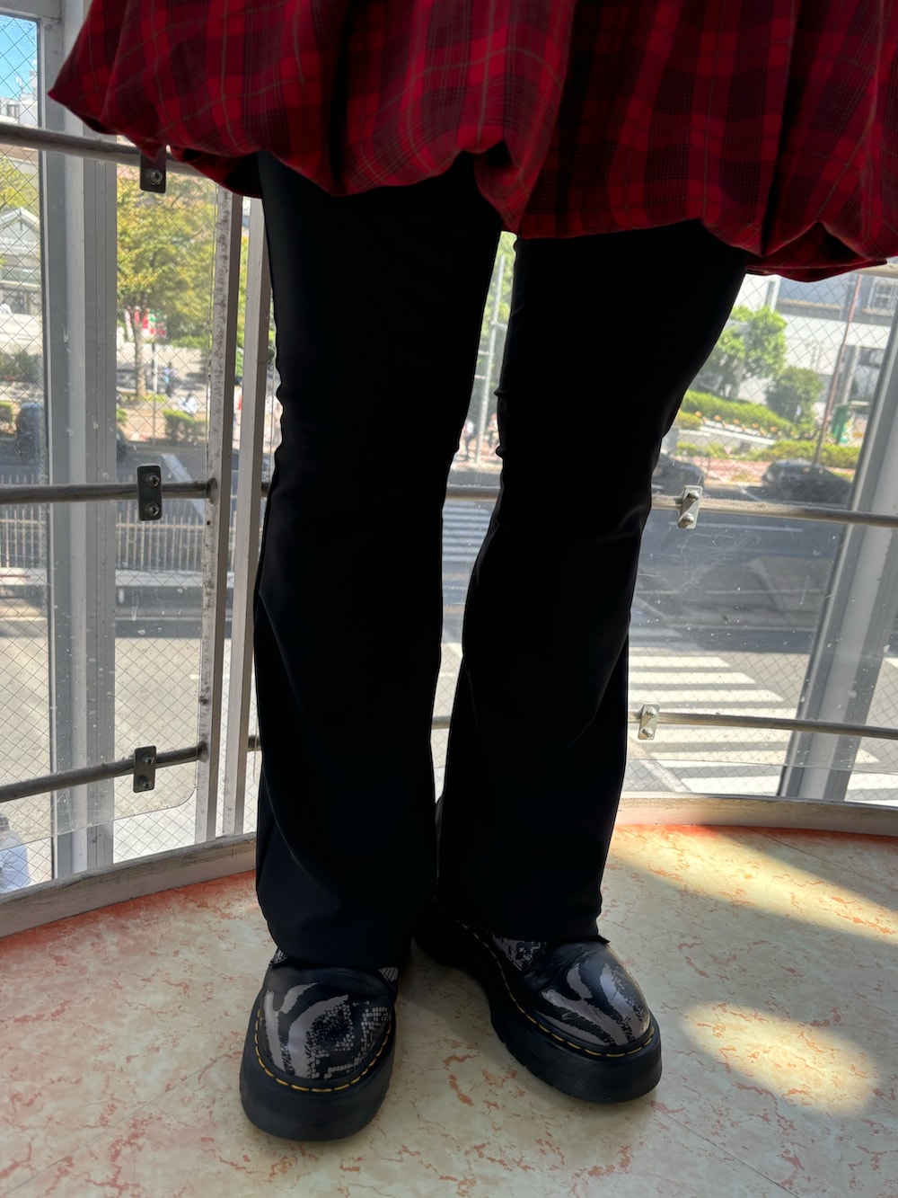 レッド系のワンピース、ブラック系のハンドバッグ、ブラック系のその他パンツを着用したレディースの秋コーディネートの10枚目の写真