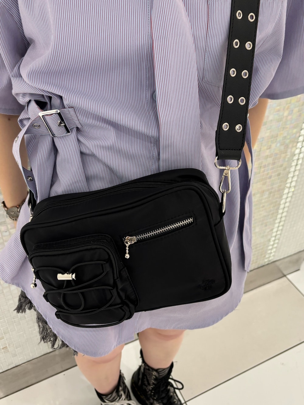 ブラック系のデニムパンツ、ブラック系のショルダーバッグ、パープル系のシャツ/ブラウスを着用したレディースの夏コーディネートの8枚目の写真