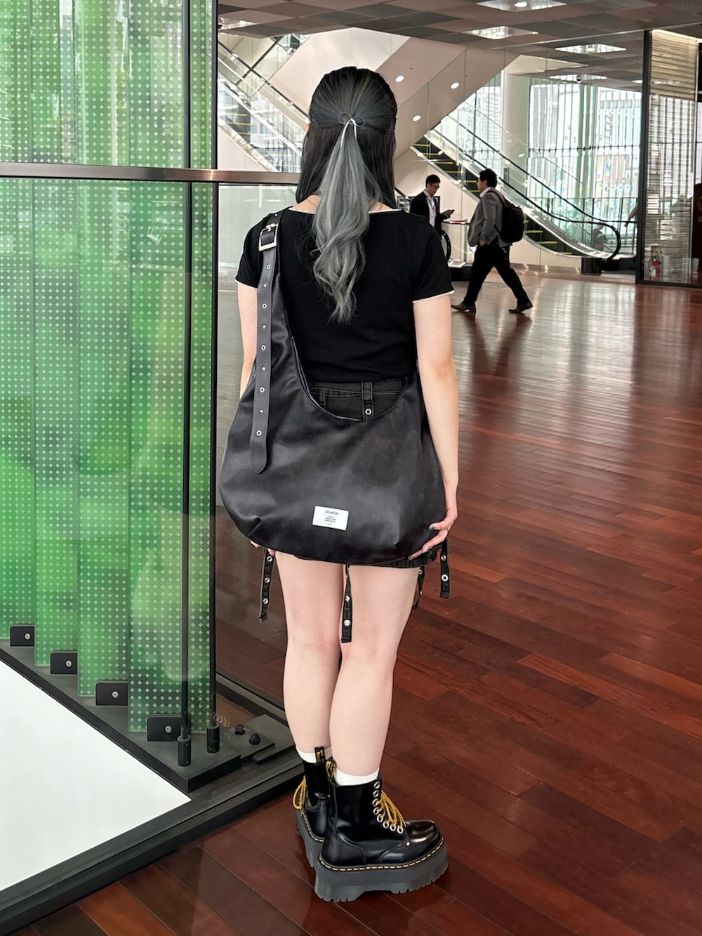 ブラック系のスカート、ブラック系のTシャツ/カットソー、ブラック系のショルダーバッグを着用したレディースの春コーディネートの3枚目の写真