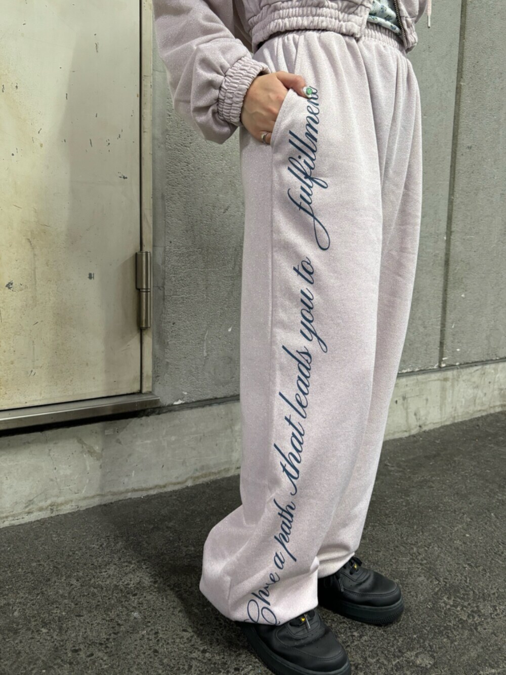 ピンク系のスウェットパンツ、ピンク系のパーカー、ホワイト系のアンサンブルを着用したレディースの春コーディネートの7枚目の写真