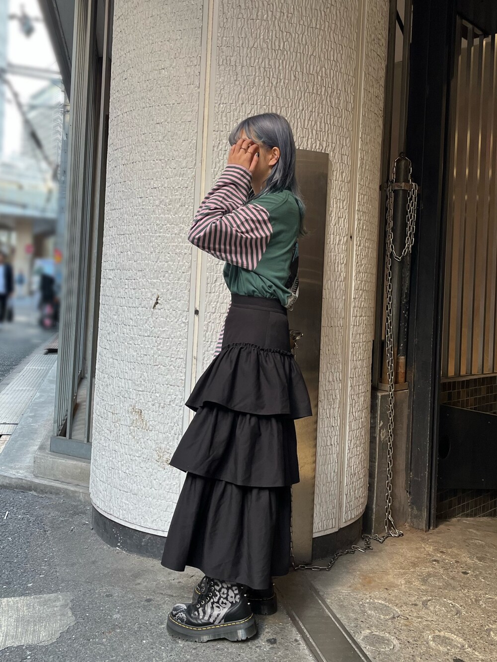 グリーン系のTシャツ/カットソー、ブラック系のスカート、シルバー系のネックレスを着用したレディースの秋コーディネートの5枚目の写真