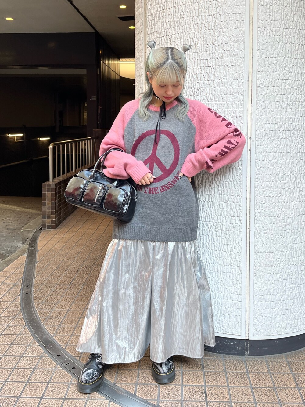 グレー系のニット/セーター、ブラック系のボストンバッグ、シルバー系のスカートを着用したレディースの冬コーディネートの2枚目の写真