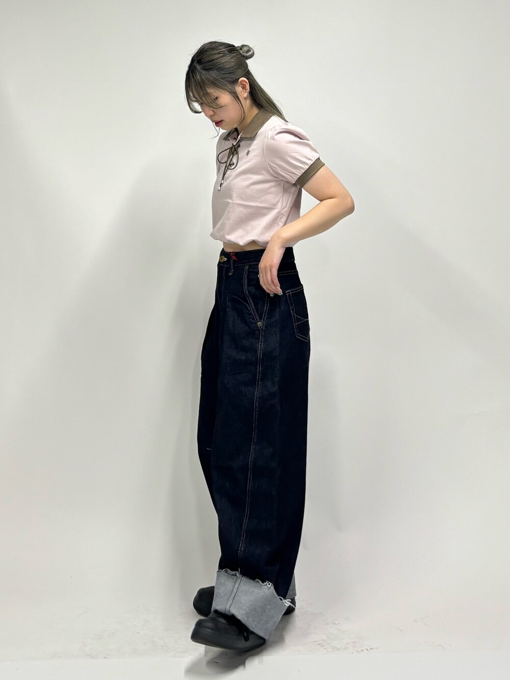 ブルー系のデニムパンツ、ピンク系のポロシャツを着用したレディースの春コーディネートの4枚目の写真