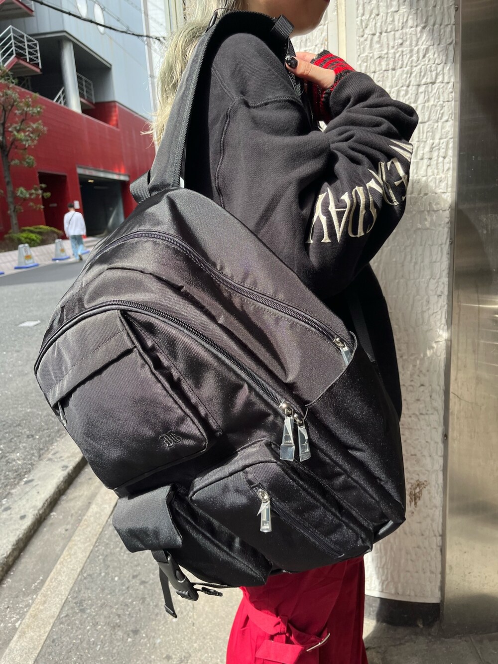 ブラック系のバックパック/リュック、ブラック系のパーカー、レッド系のその他パンツを着用したレディースの秋コーディネートの8枚目の写真