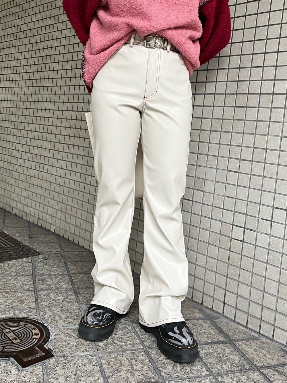 ホワイト系のハンドバッグ、レッド系のニット/セーター、ホワイト系のその他パンツを着用したレディースの冬コーディネートの6枚目の写真