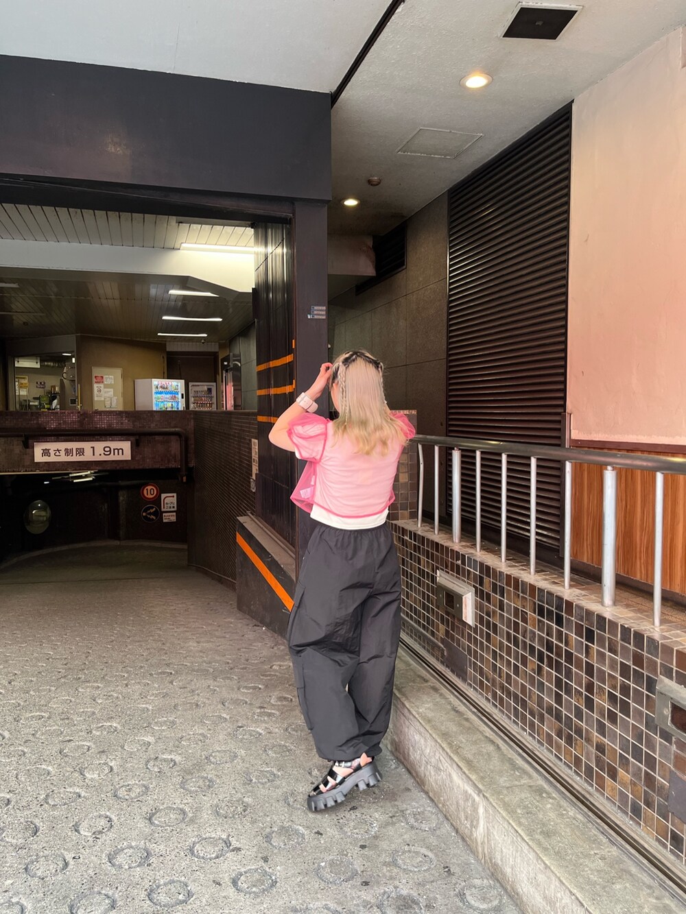 ブラック系のサンダル、ブラック系のカーゴパンツ、ホワイト系のTシャツ/カットソーを着用したレディースの夏コーディネートの4枚目の写真