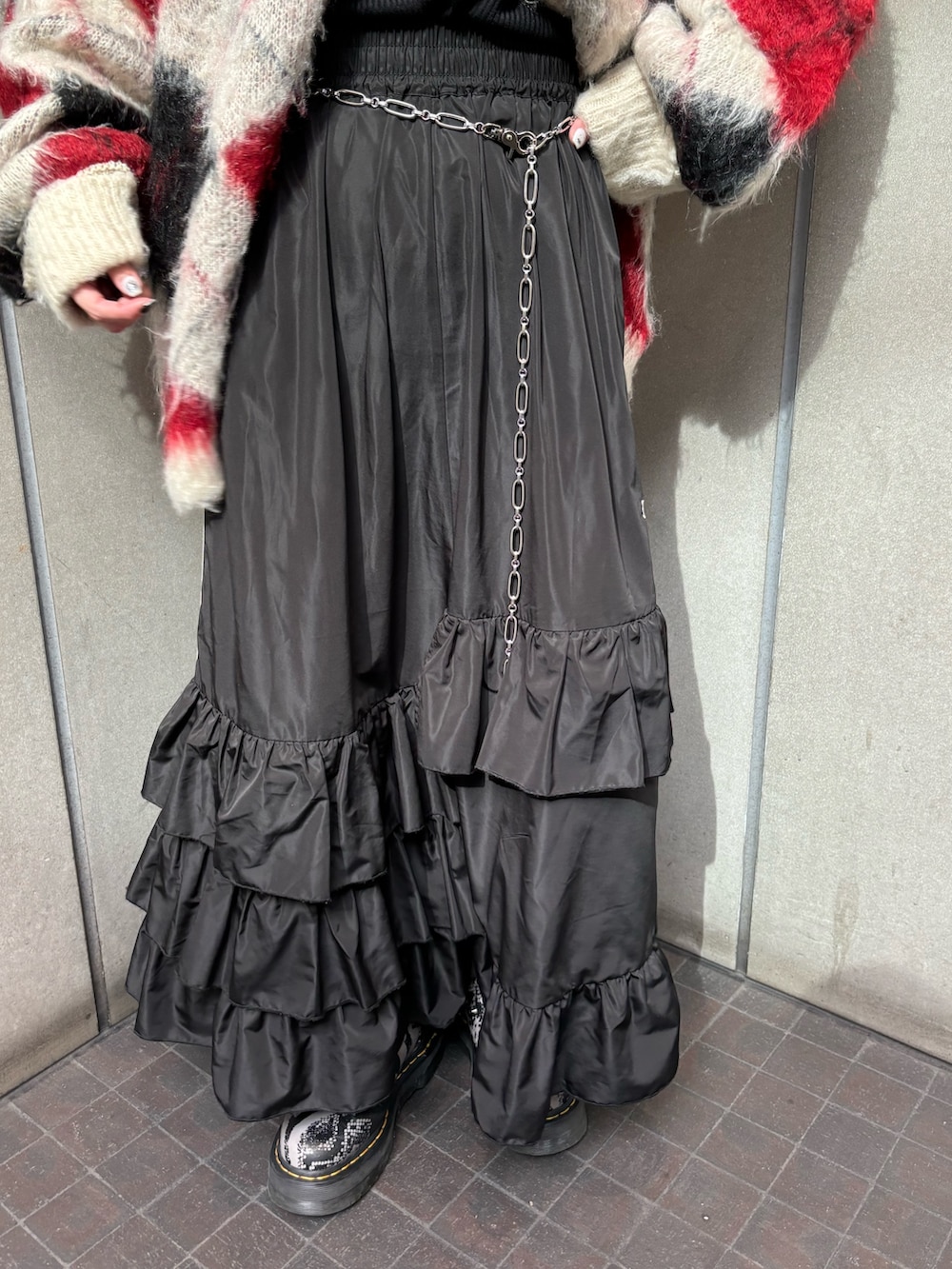 ブラック系のスカート、ホワイト系のカーディガン/ボレロ、ブラック系のTシャツ/カットソーを着用したレディースの秋コーディネートの7枚目の写真