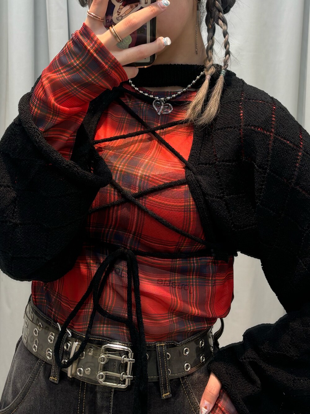 ブラック系のデニムパンツ、レッド系のワンピース、ブラック系のニット/セーターを着用したレディースの夏コーディネートの4枚目の写真