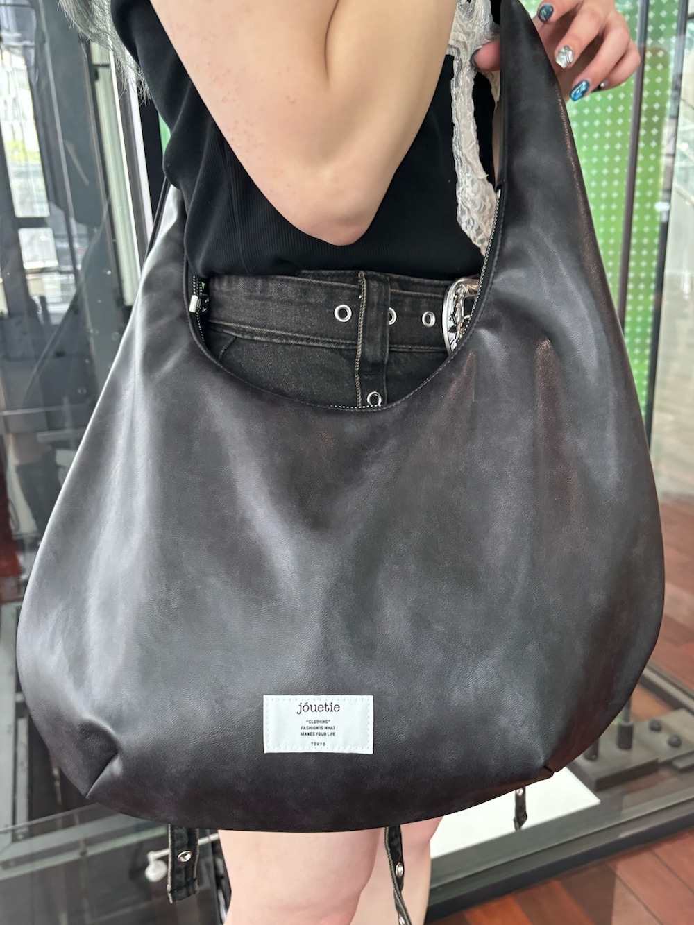 ブラック系のスカート、ブラック系のTシャツ/カットソー、ブラック系のショルダーバッグを着用したレディースの春コーディネートの8枚目の写真