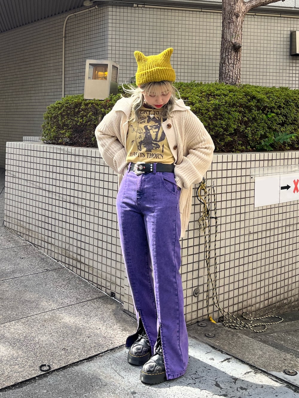 パープル系のデニムパンツ、ホワイト系のカーディガン/ボレロ、イエロー系のTシャツ/カットソーを着用したレディースの秋コーディネートの2枚目の写真