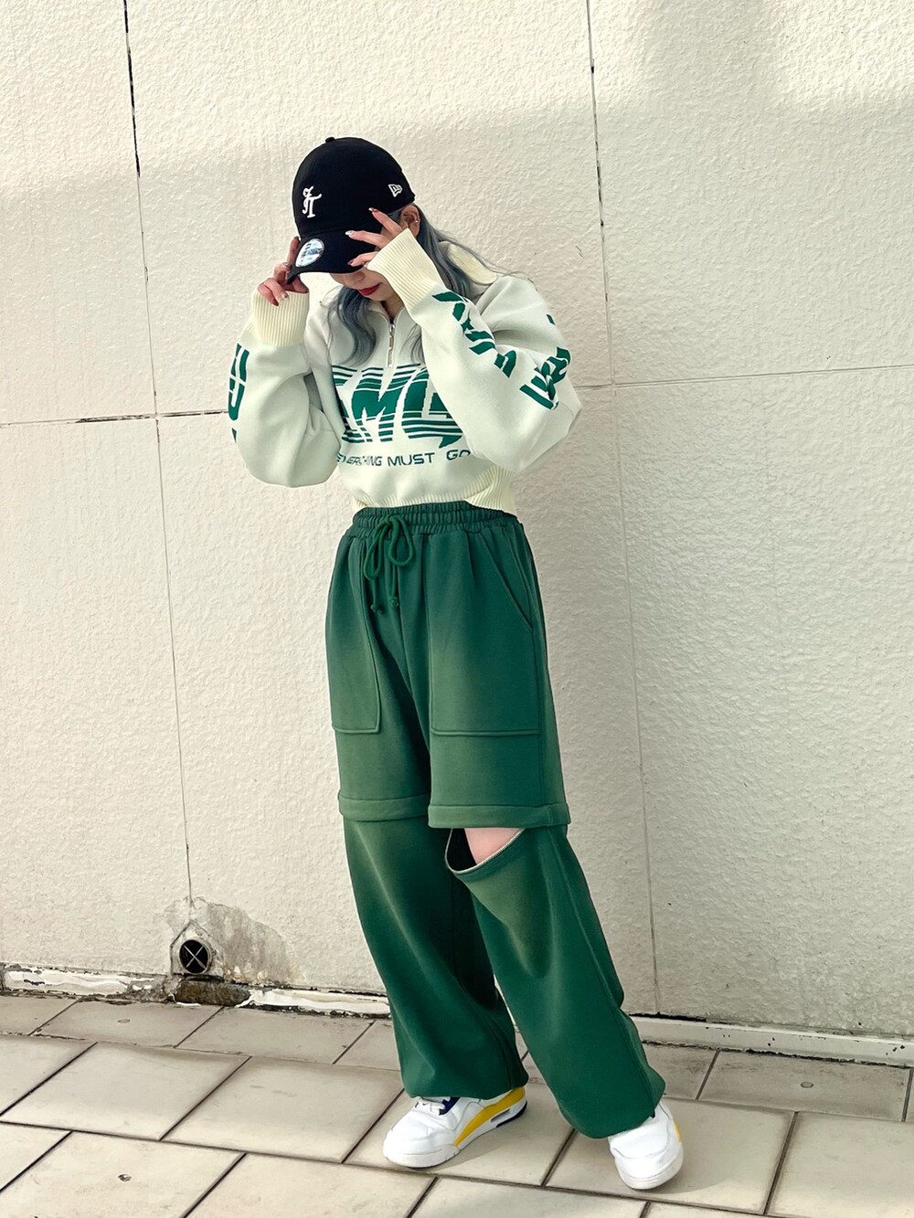 グリーン系のスウェットパンツ、ホワイト系のニット/セーター、シルバー系のネックレスを着用したレディースの冬コーディネートの2枚目の写真