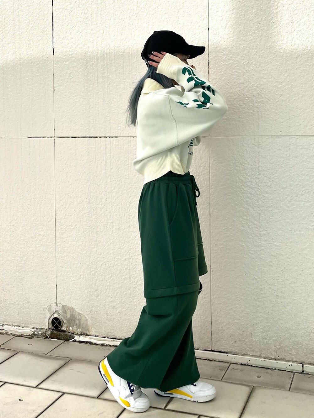 グリーン系のスウェットパンツ、ホワイト系のニット/セーター、シルバー系のネックレスを着用したレディースの冬コーディネートの3枚目の写真