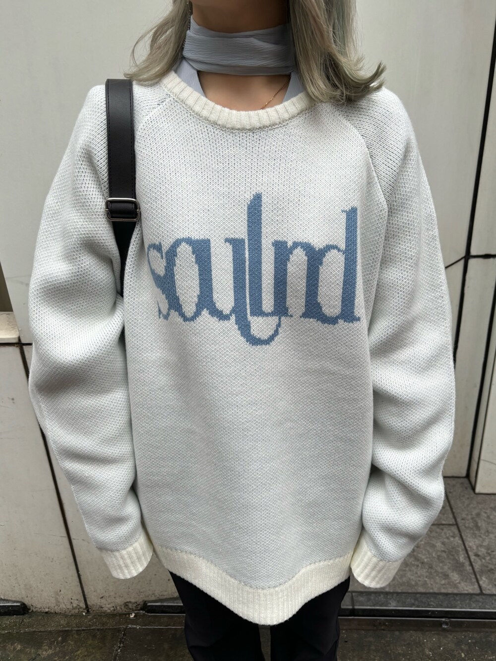 ホワイト系のニット/セーター、ブルー系のシャツ/ブラウス、ブラック系のバックパック/リュックを着用したレディースの春コーディネートの7枚目の写真