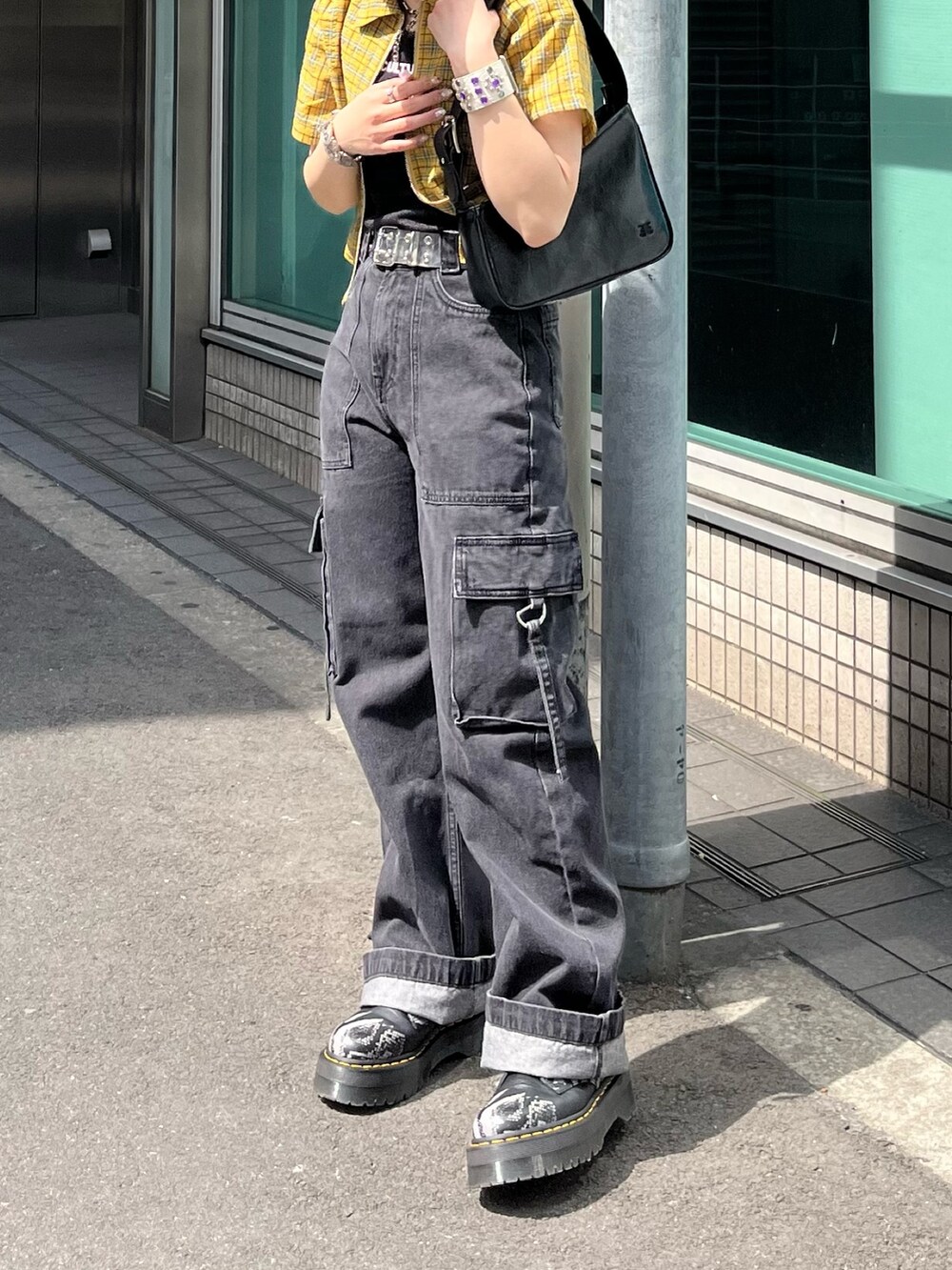 ブラック系のハンドバッグ、ブラック系のカーゴパンツ、ブラック系のタンクトップを着用したレディースの春コーディネートの4枚目の写真